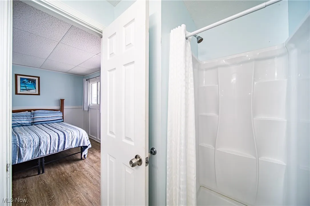 Bedroom featuring a paneled ceiling and dark hardwood / wood-style flooring
