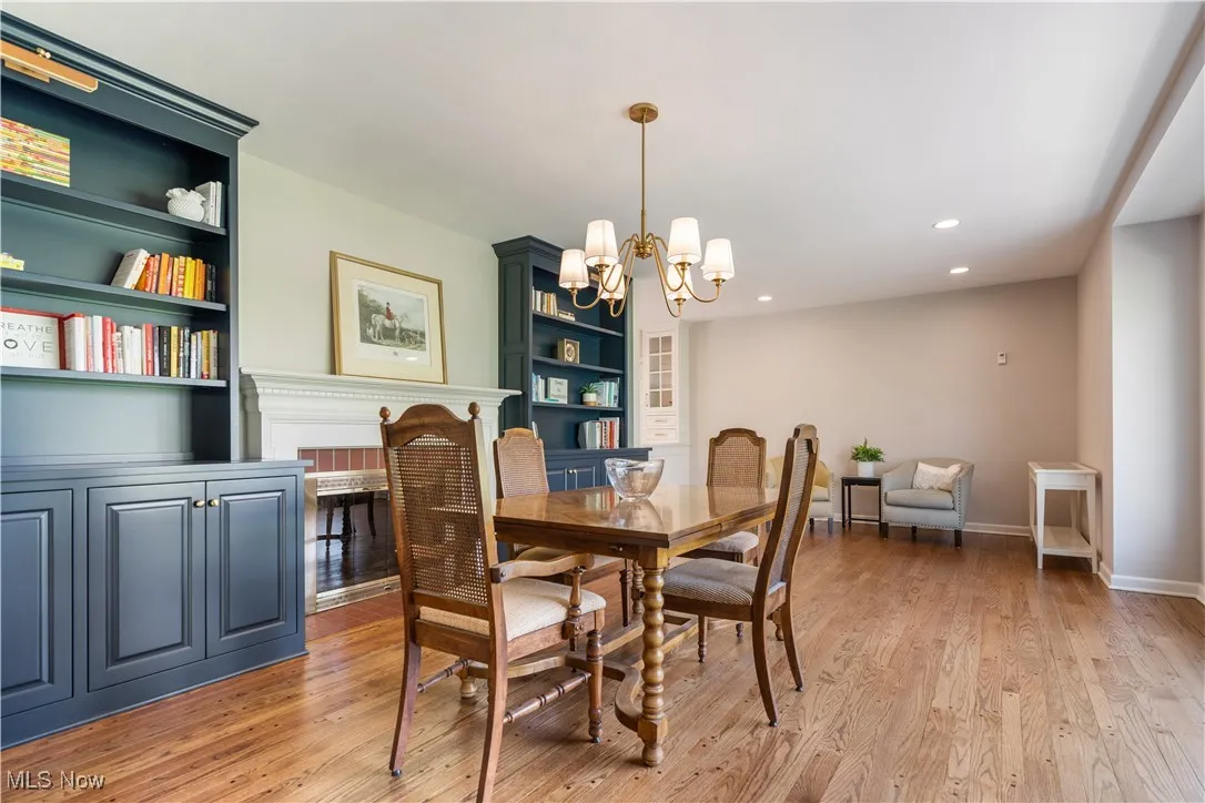 Dining room featuring built in shelves, recessed lighting, a chandelier, and light wood-style flooring