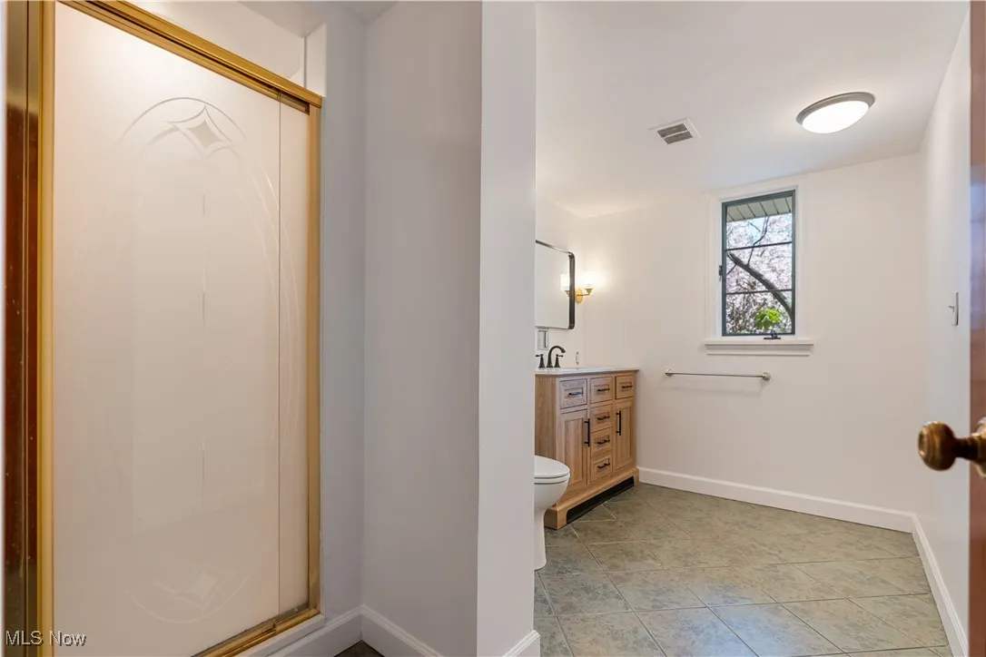 Full bath with toilet, vanity, baseboards, tile patterned flooring, and visible vents