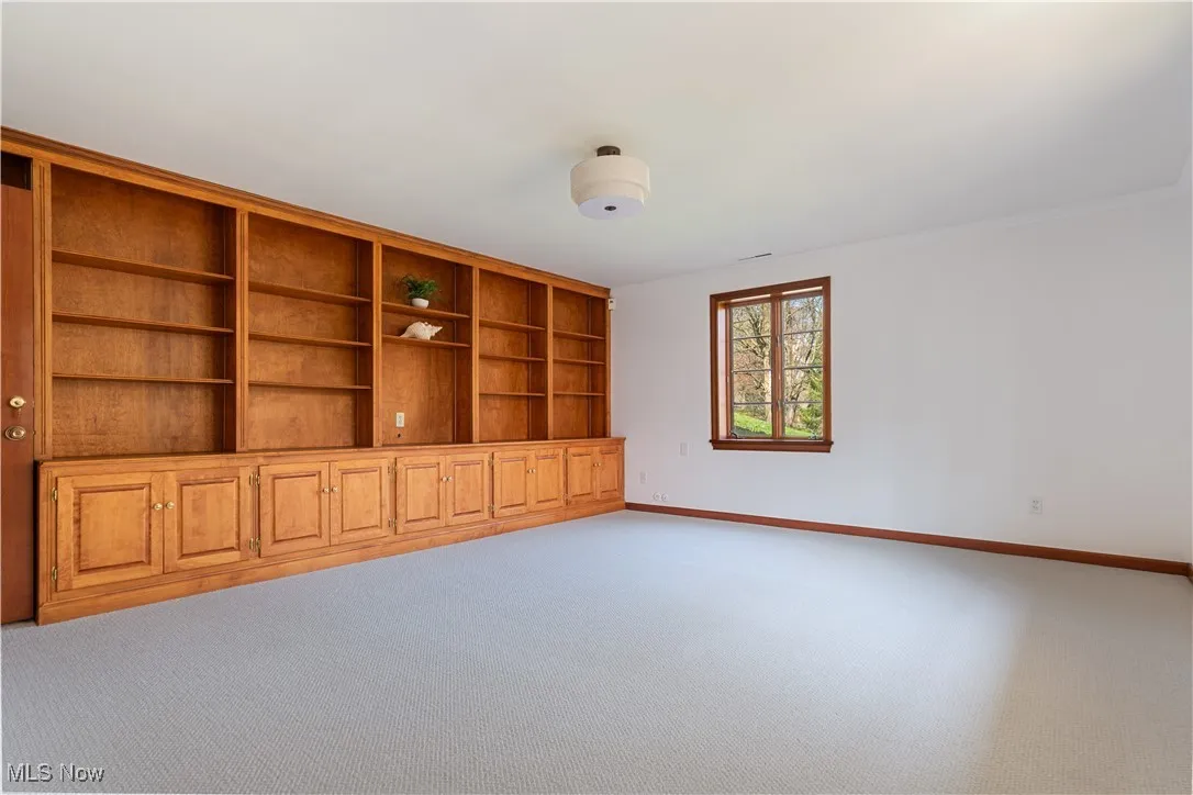 Carpeted empty room featuring baseboards and crown molding