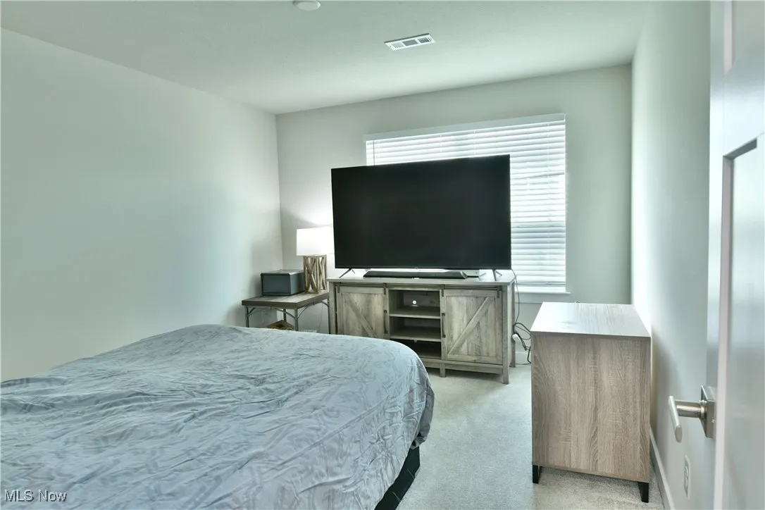 Second bedroom featuring visible vents and light colored carpet