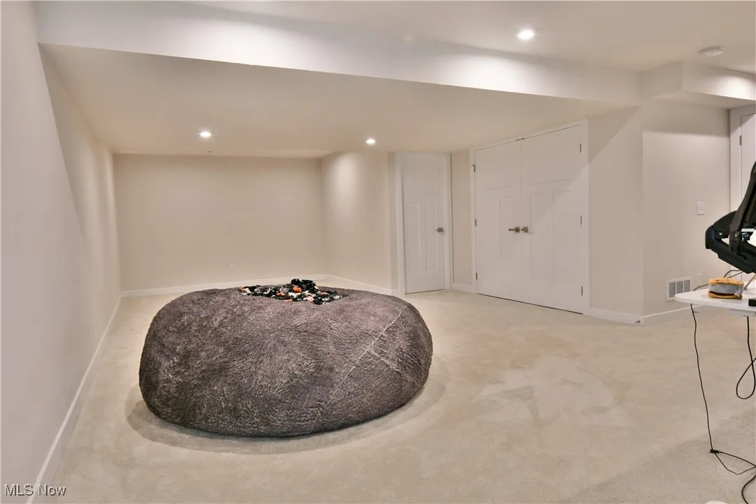 Basement with recessed lighting, carpet, and closets for storage.