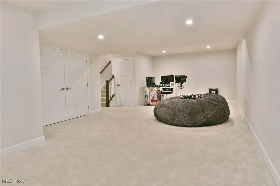 Basement with recessed lighting, carpet, baseboards, and stairway