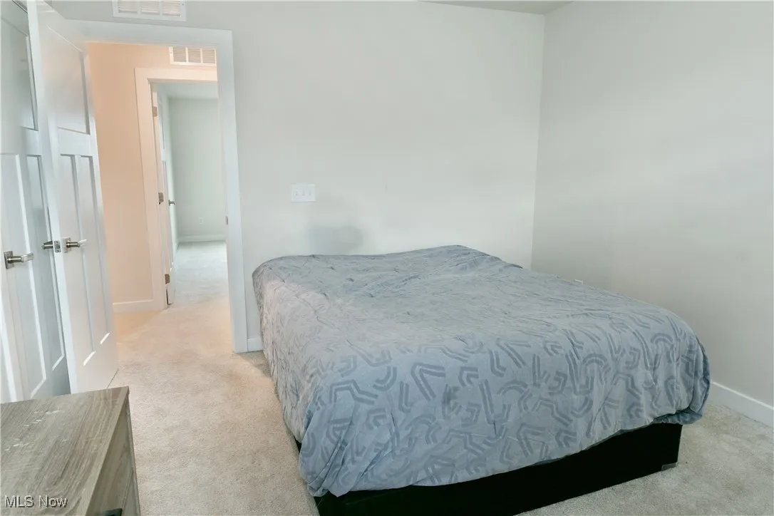 Bedroom featuring visible vents, baseboards, and light carpet