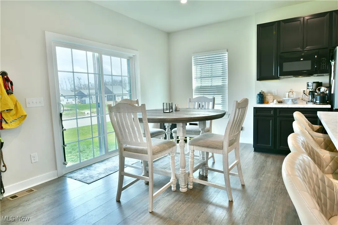 Dining area with light wood-style floors, plenty of natural light, and visible vents