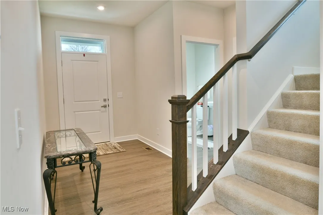 Foyer entrance featuring recessed lighting, stairway, baseboards, and wood finished floors