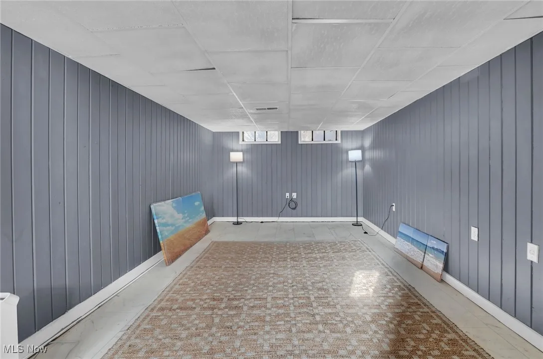 Basement featuring baseboards and wood walls