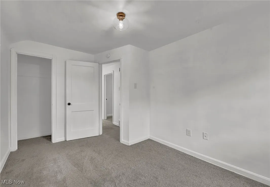 Unfurnished bedroom with baseboards, a closet, and carpet