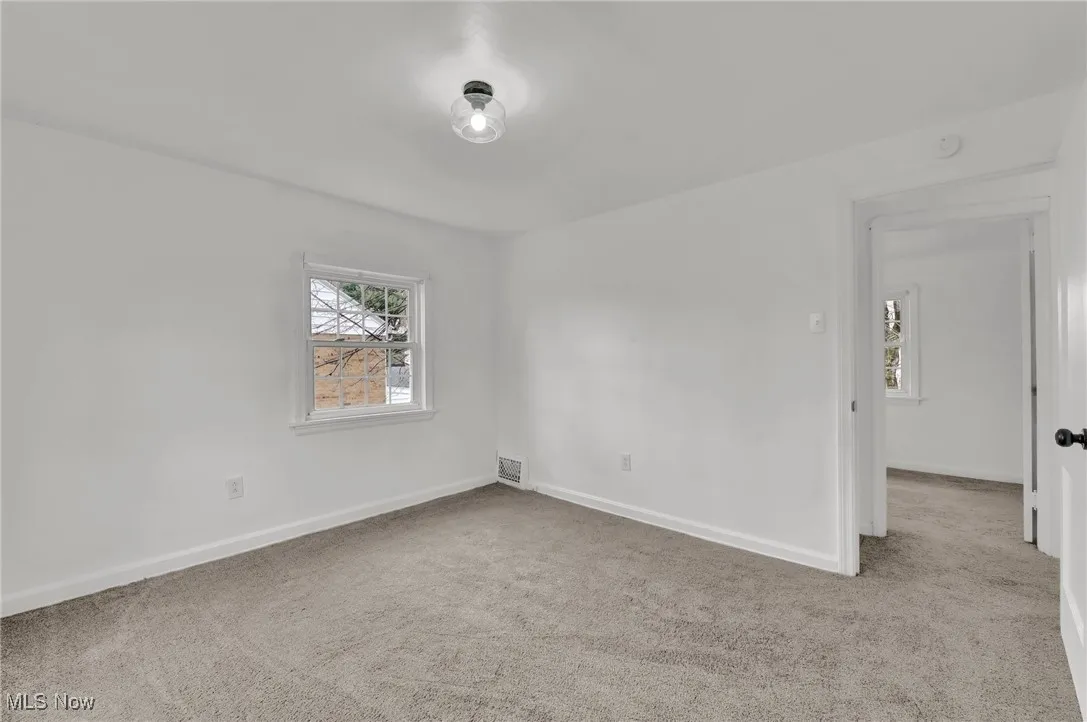Carpeted spare room with baseboards and visible vents