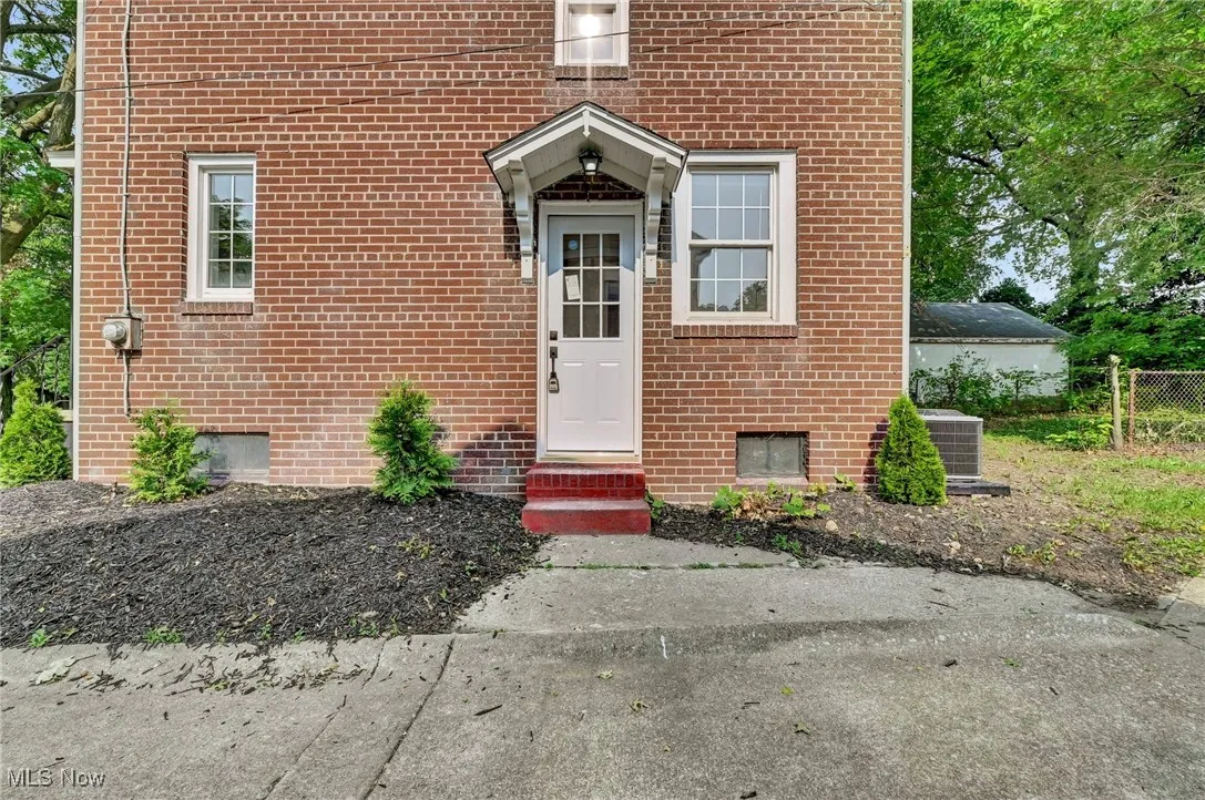 Side entrance featuring brick siding