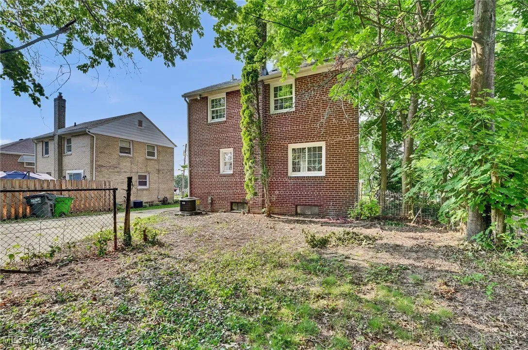 Rear view of property featuring brick siding and central AC unit