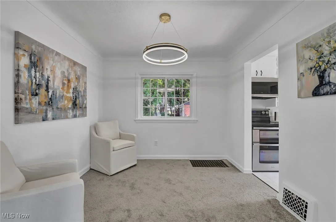 Dining area with carpet floors, baseboards, and a chandelier