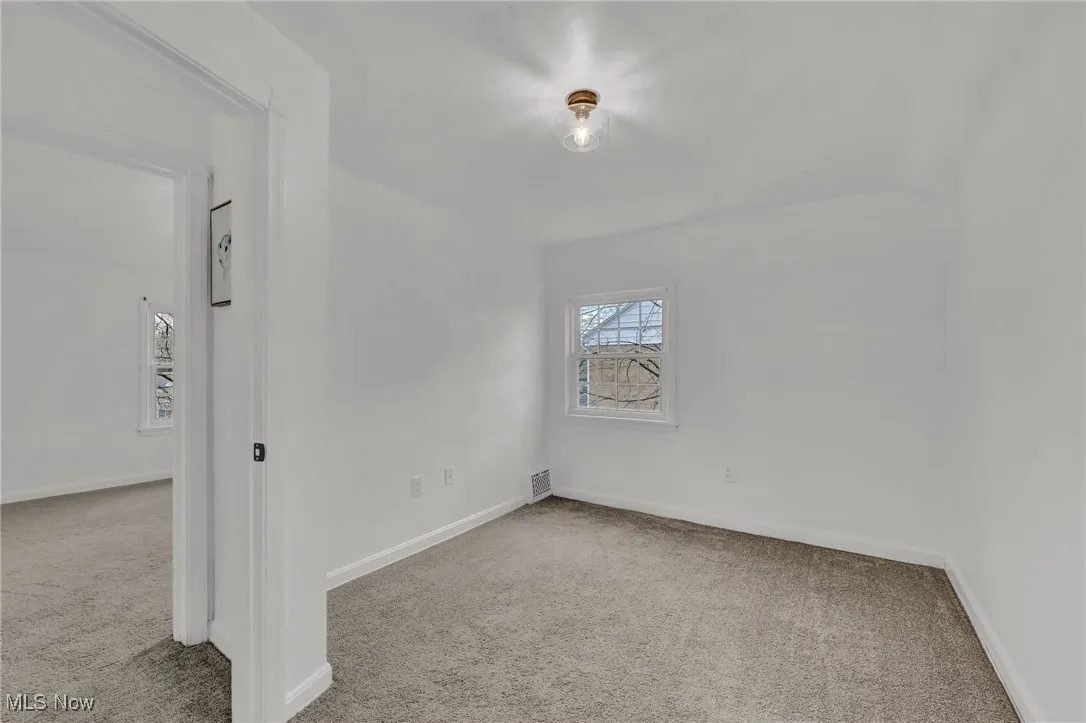 Carpeted spare room with baseboards and visible vents