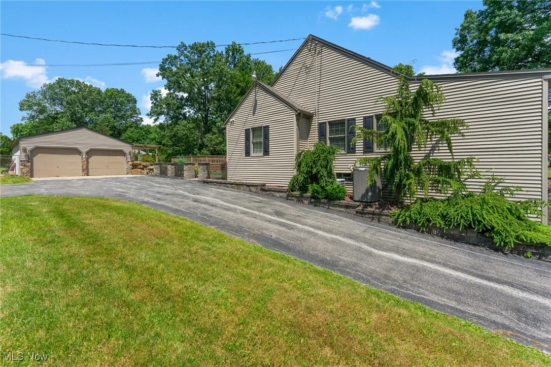 View of front of property featuring an outdoor structure, a garage, and a front lawn