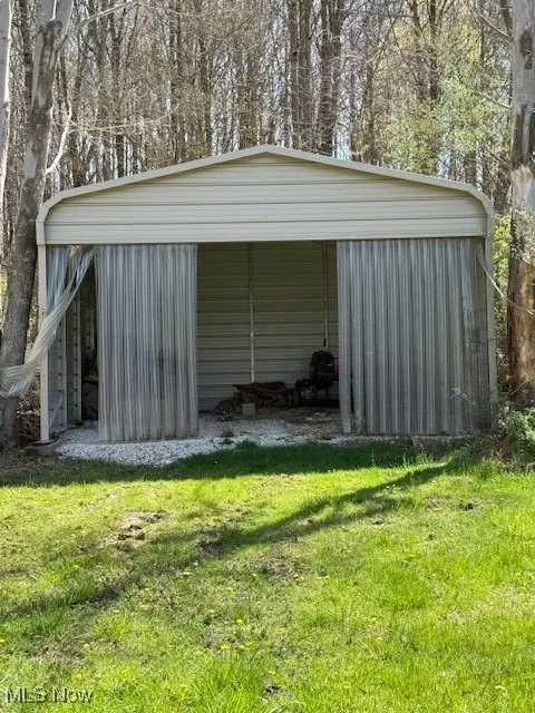 View of pole building featuring a carport and a yard