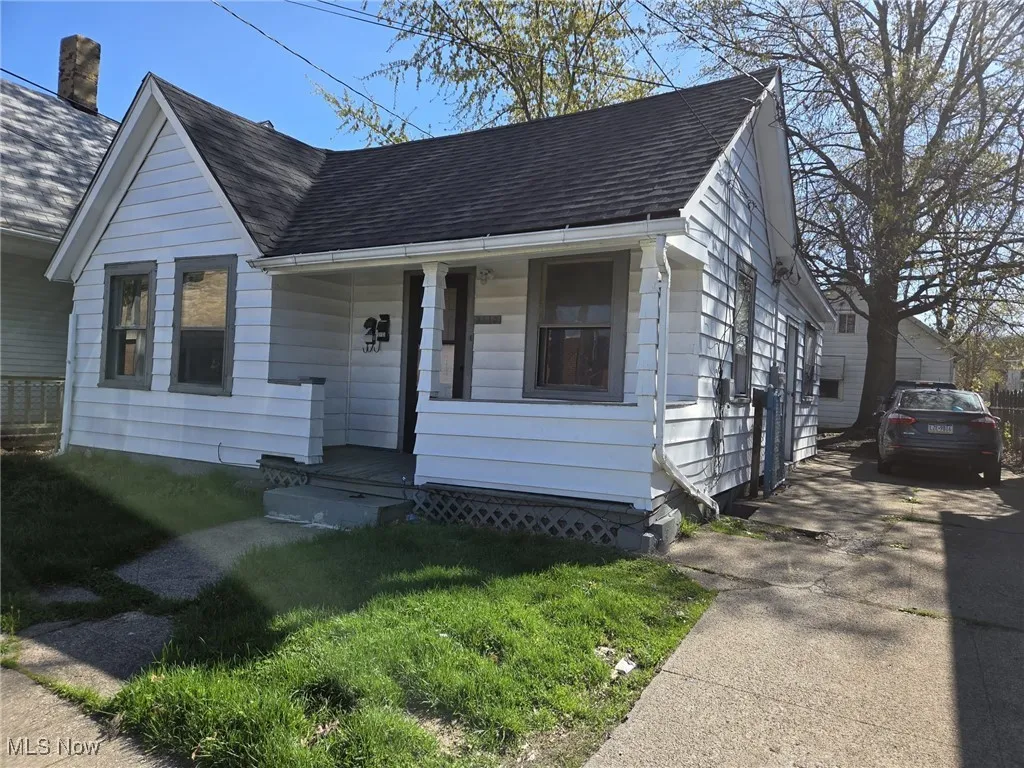 Bungalow with a shingled roof and covered porch