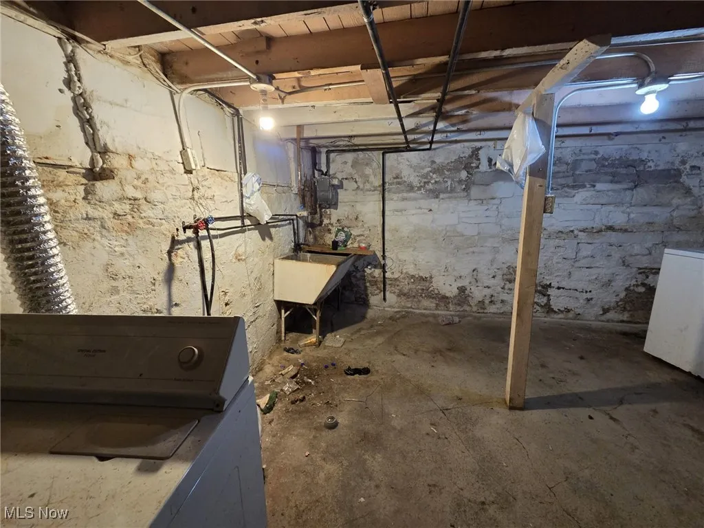 Unfinished basement featuring washer / dryer and a sink
