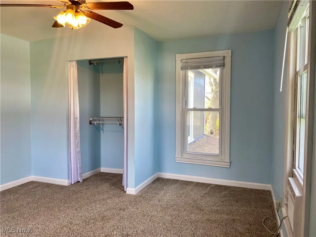 Unfurnished bedroom featuring baseboards, a ceiling fan, carpet flooring, and a closet
