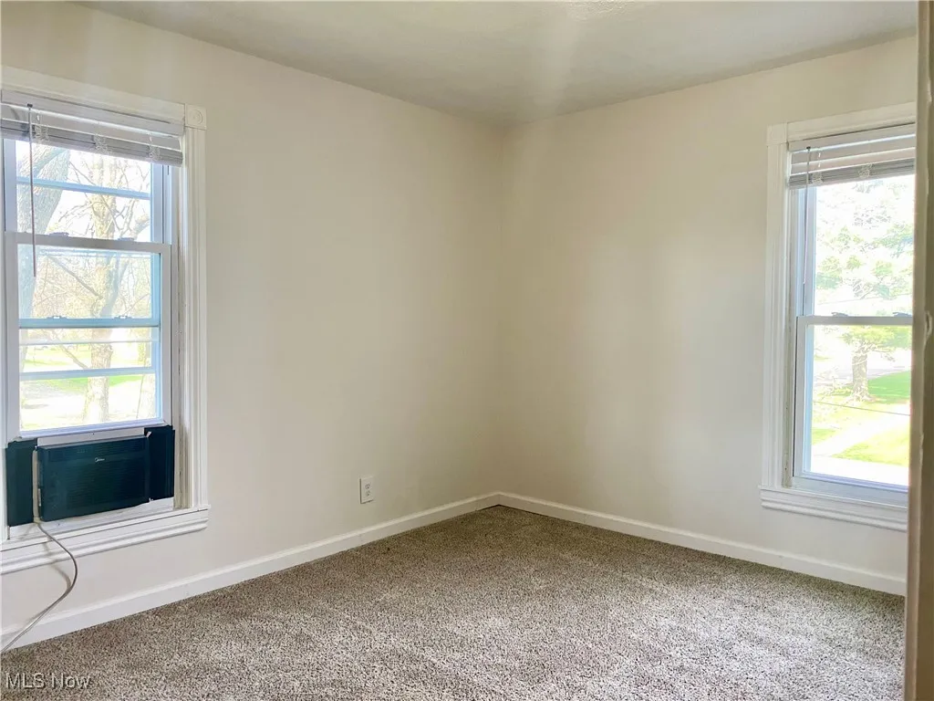Spare room featuring cooling unit, baseboards, and carpet