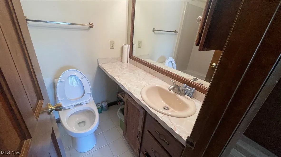 Bathroom with vanity, toilet, and tile patterned flooring