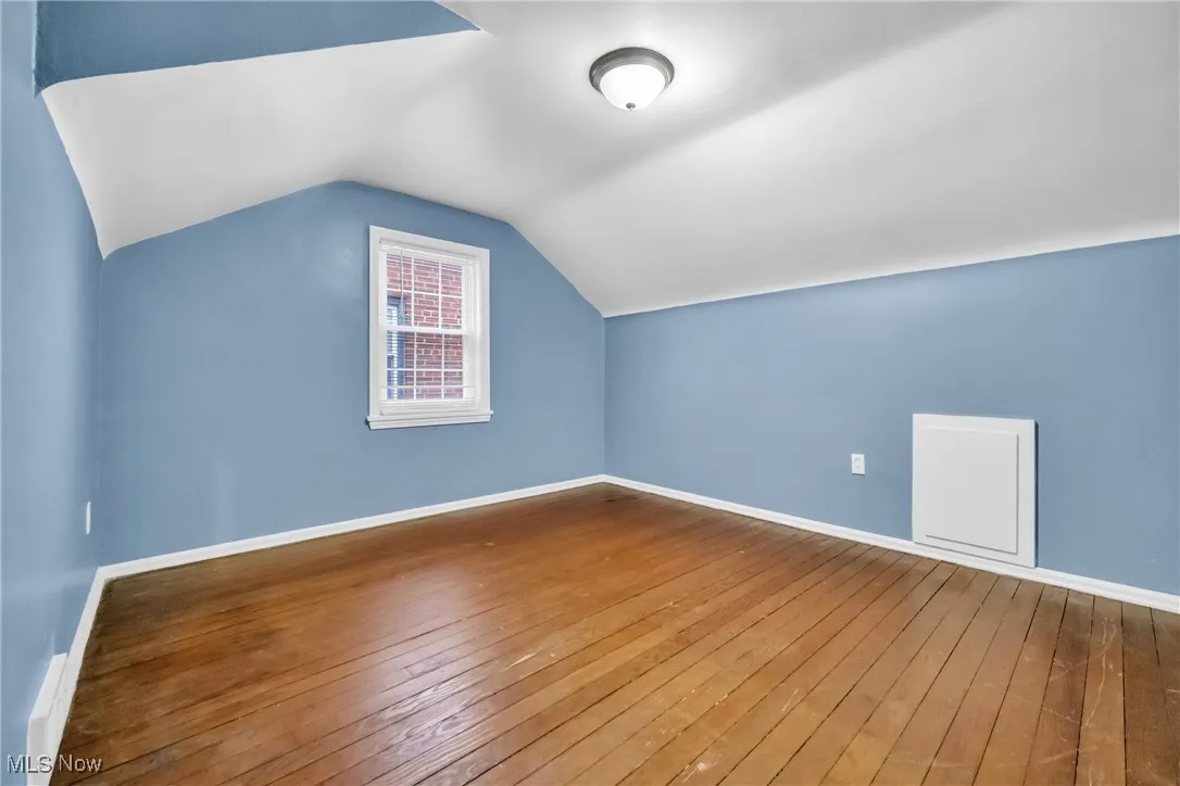Bonus room featuring hardwood / wood-style floors, vaulted ceiling, and baseboards