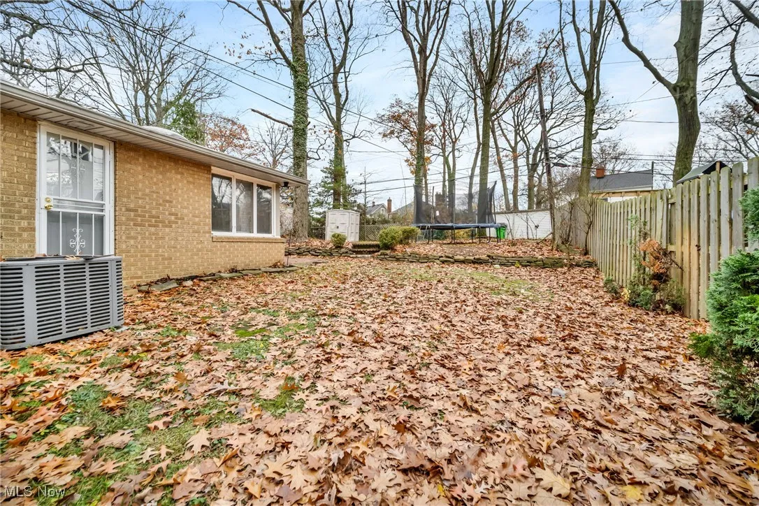 View of yard with a fenced backyard, cooling unit, and a trampoline