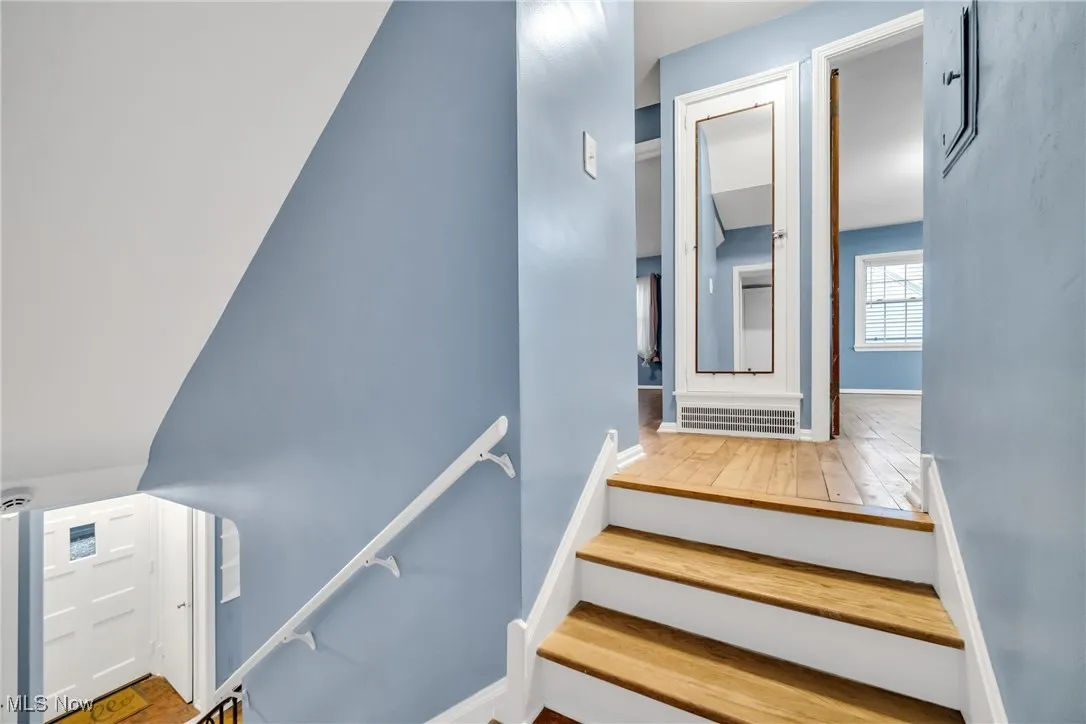 Staircase with wood finished floors and baseboards