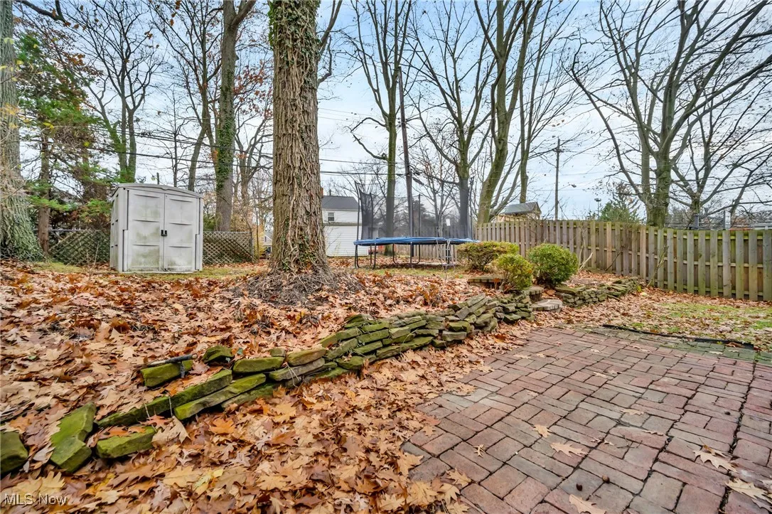 View of yard featuring a fenced backyard, a trampoline, a patio area, an outdoor structure, and a shed