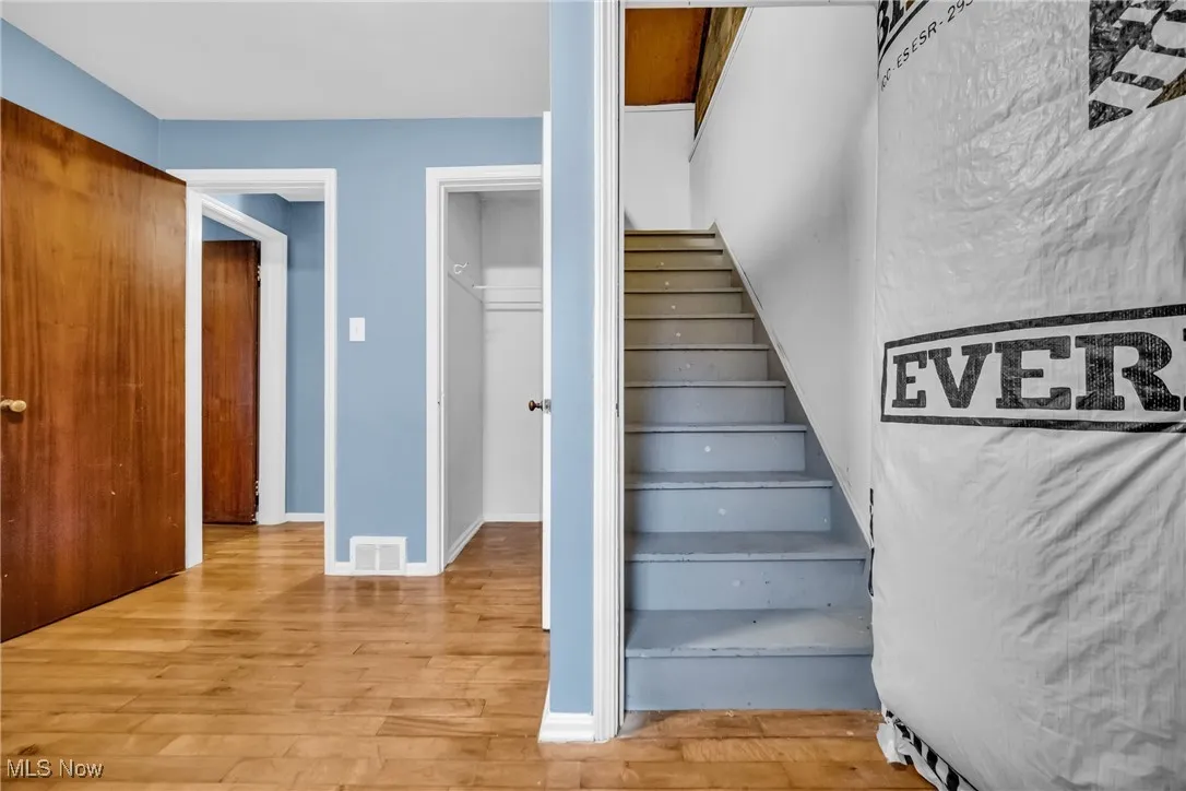 Staircase featuring wood finished floors and visible vents