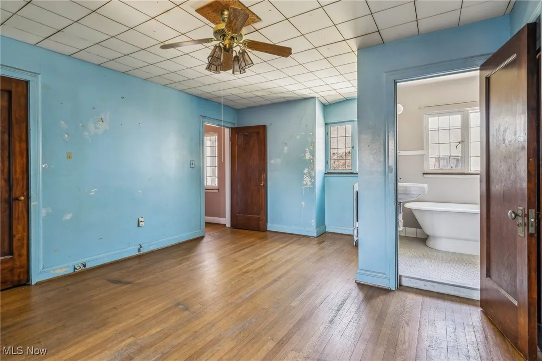 Unfurnished bedroom featuring wood-type flooring, baseboards, and a paneled ceiling