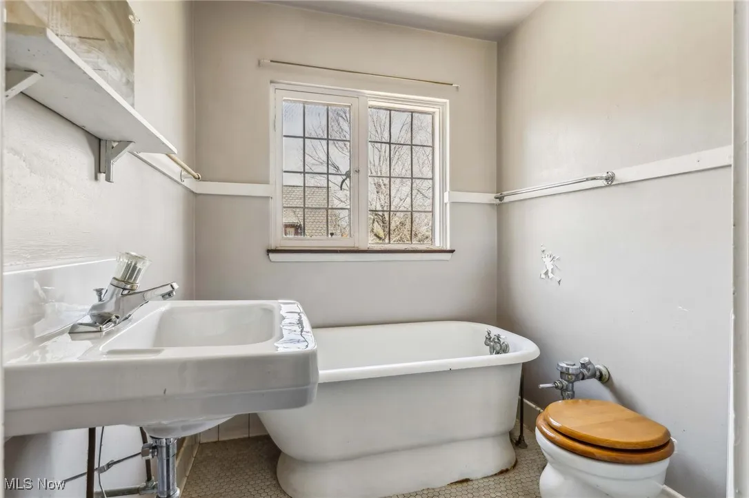 Full bath featuring a freestanding bath and tile patterned flooring