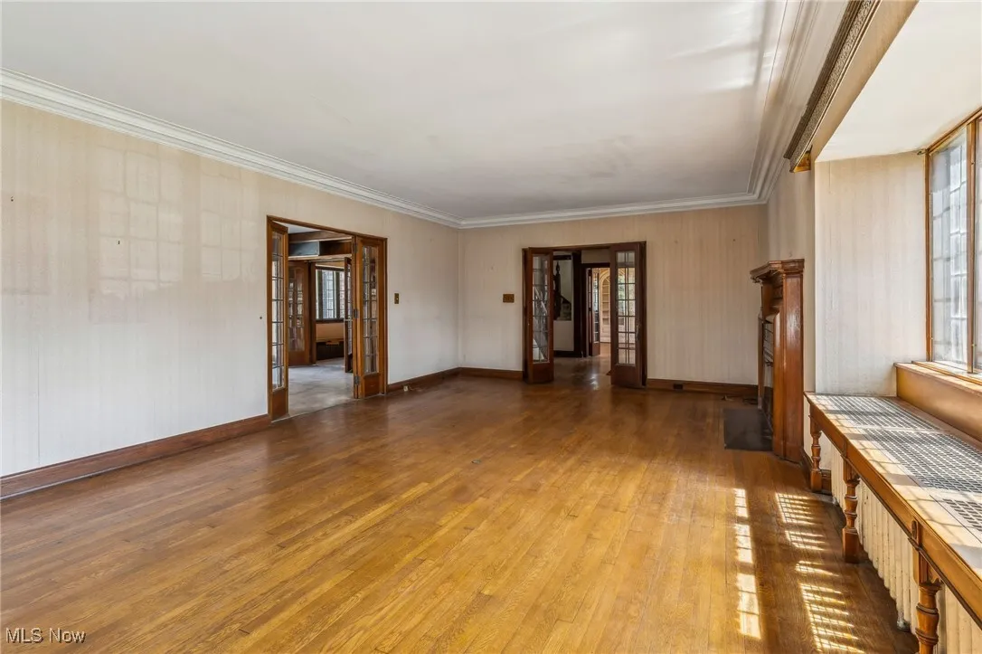 Empty room featuring hardwood / wood-style flooring, baseboards, and a healthy amount of sunlight