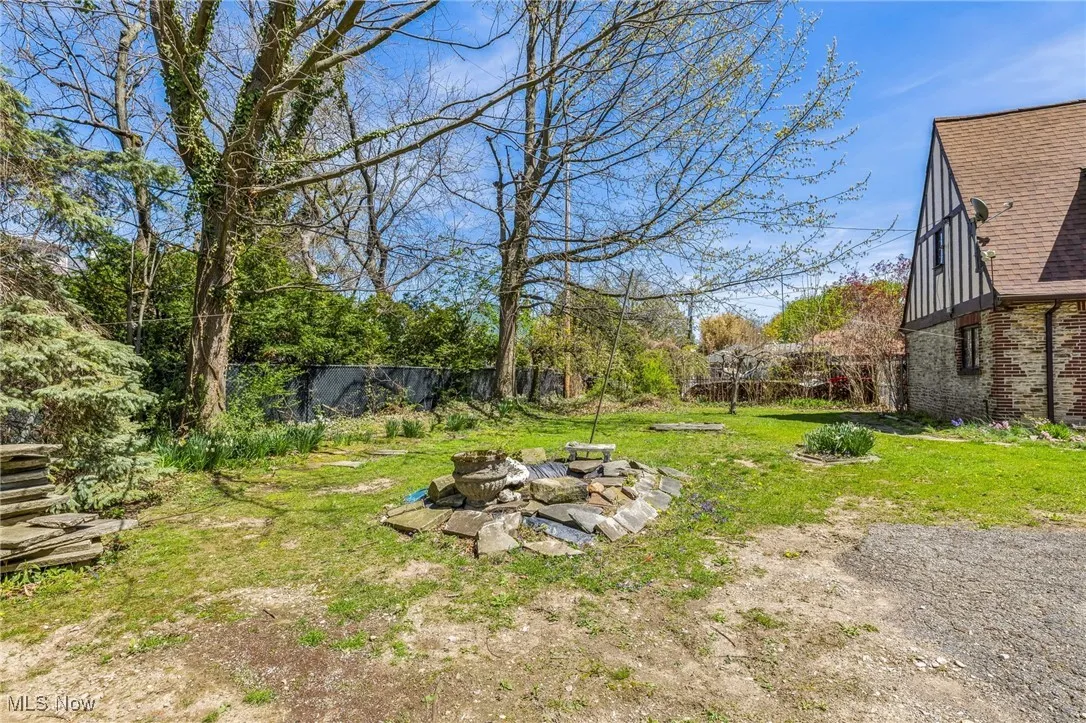 View of yard featuring a fire pit and fence