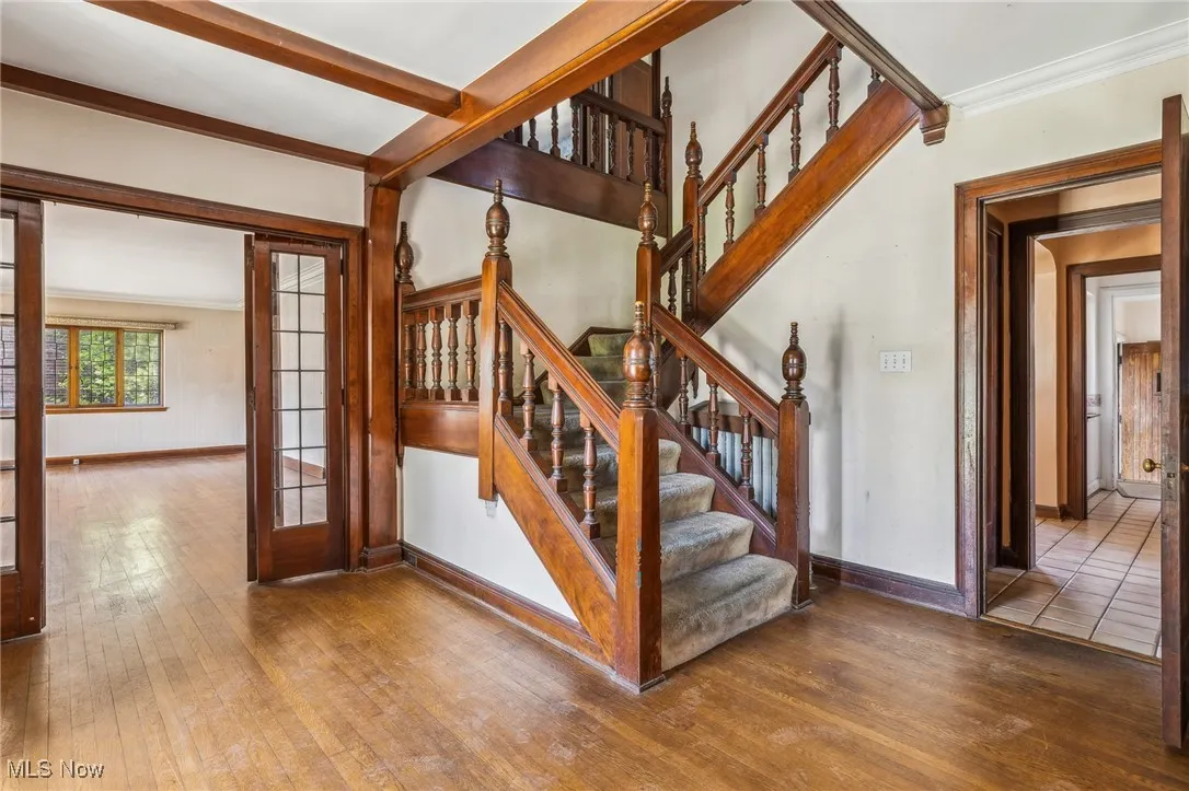 Staircase with hardwood / wood-style floors and baseboards