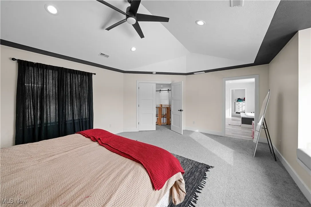 Bedroom featuring vaulted ceiling, baseboards, carpet flooring, visible vents, and recessed lighting