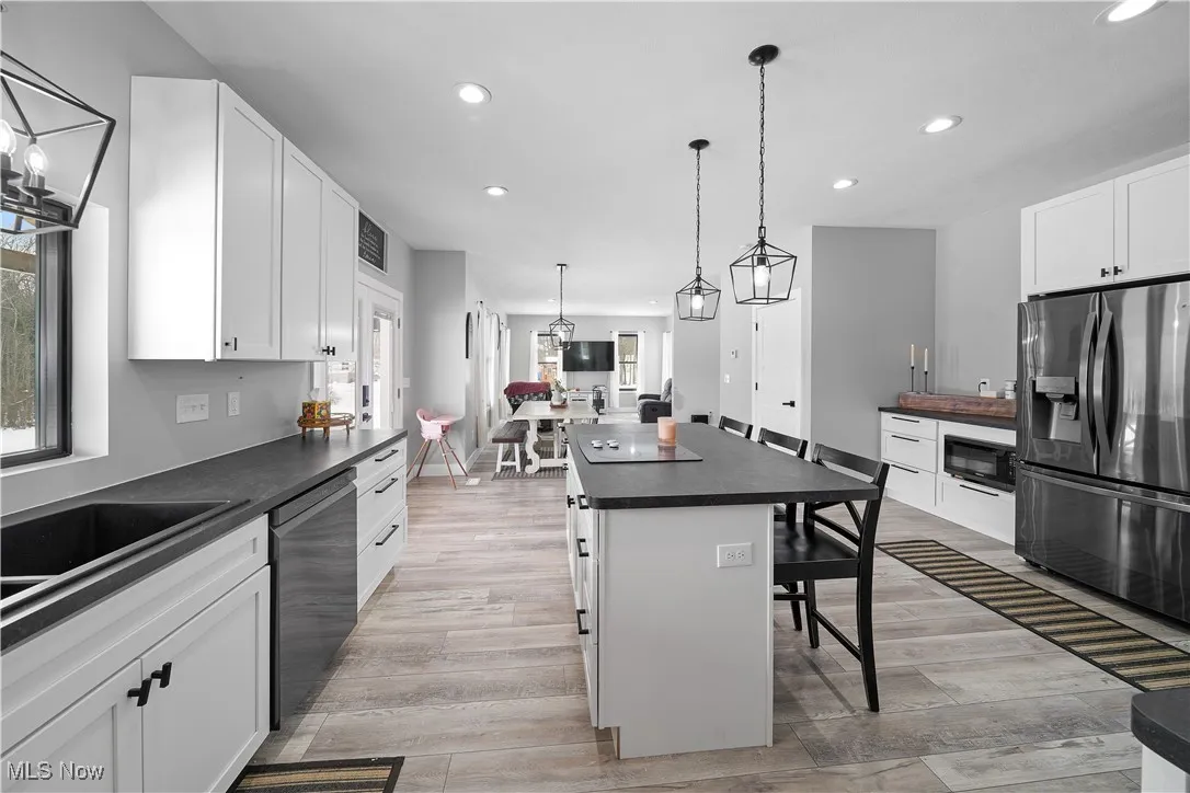 Kitchen with a kitchen bar, dark countertops, plenty of natural light, and stainless steel appliances