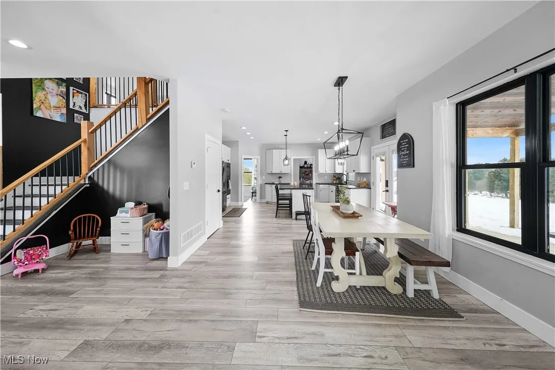 Dining room featuring recessed lighting, light wood-style flooring, stairs, and baseboards