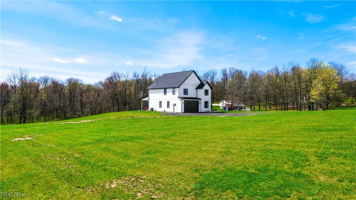 View of yard featuring a barn and a wooded view