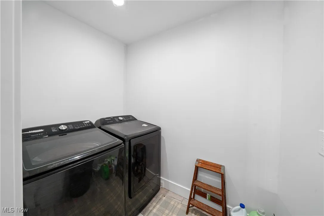 Washroom with baseboards, washer and clothes dryer, and laundry area