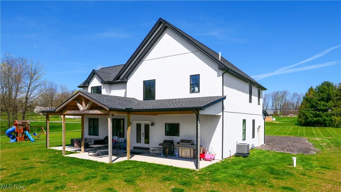 Back of house featuring central AC, a patio area, a playground, french doors, and a yard