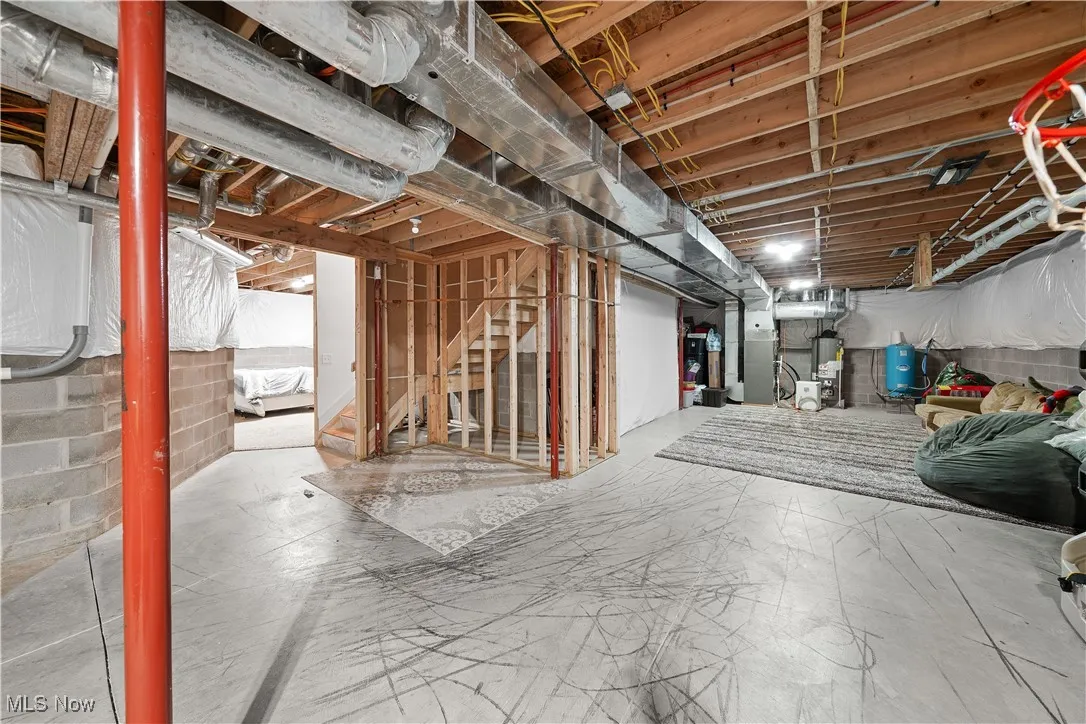 Unfinished below grade area featuring gas water heater