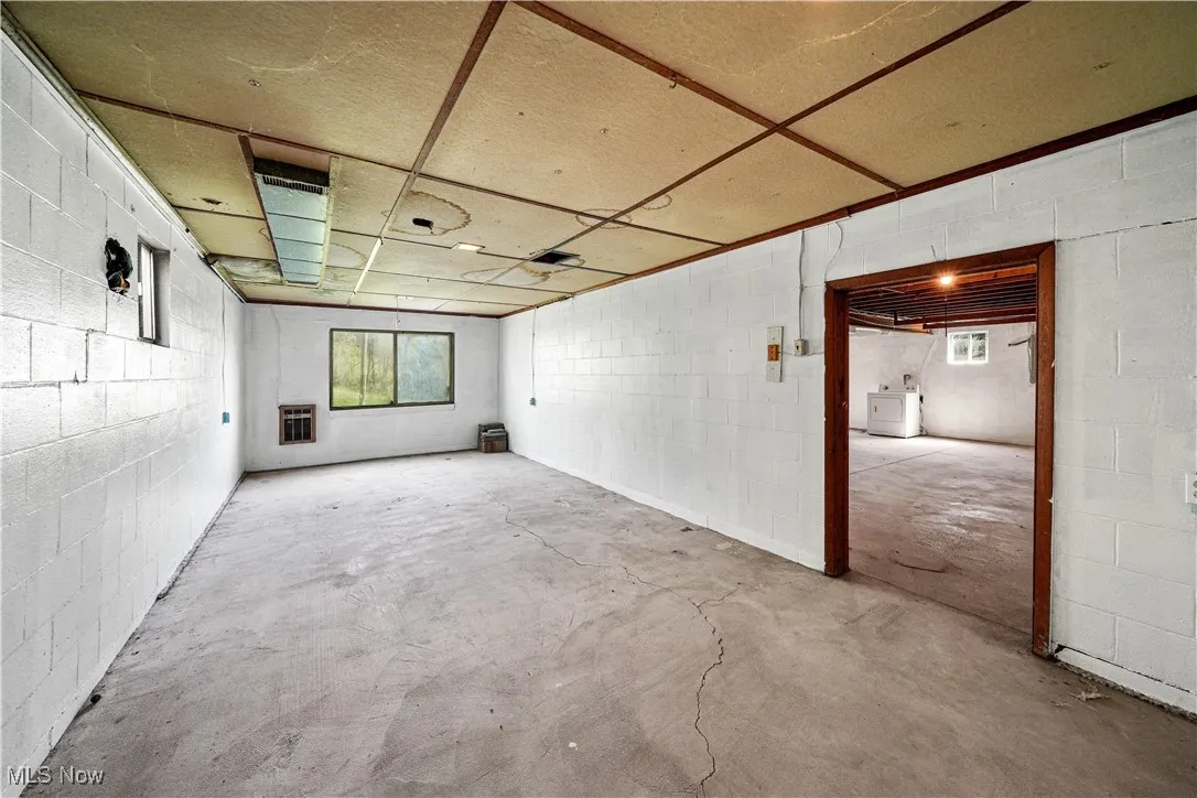 Below grade area with concrete block wall, washer / dryer, and a healthy amount of sunlight