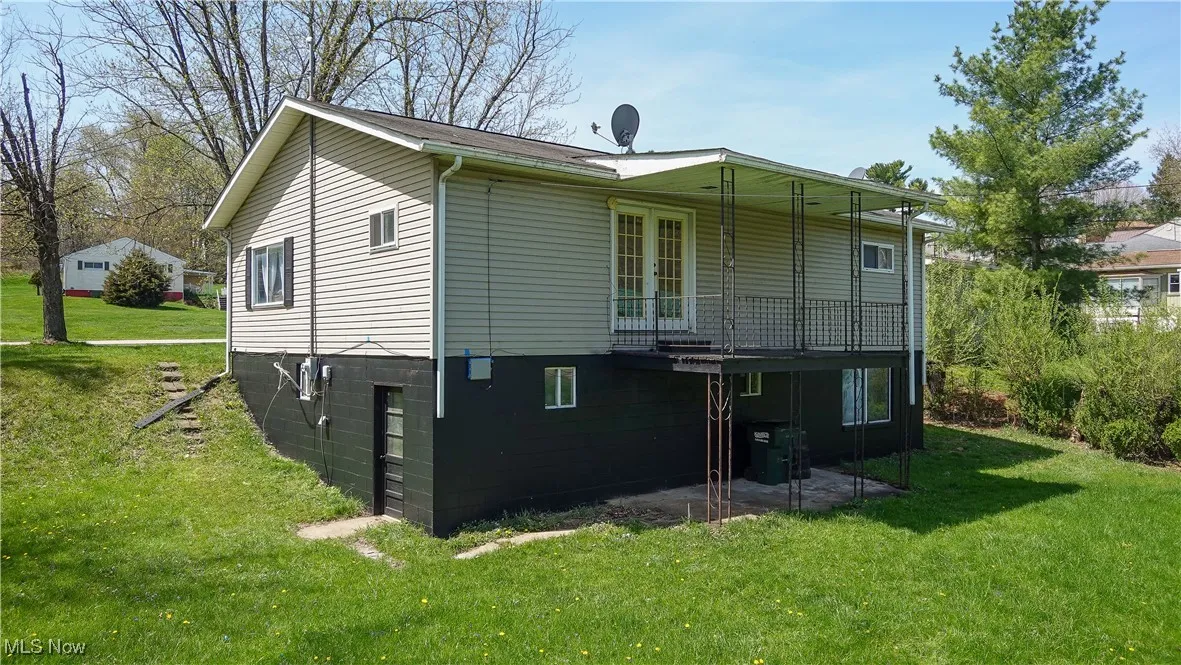 Rear view of house featuring french doors and a lawn