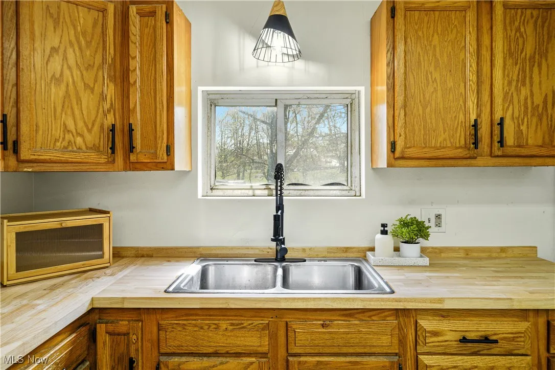 Kitchen featuring brown cabinets, butcher block counters, and a sink