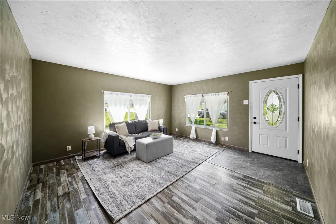 Living room with wood finished floors, a wealth of natural light, and a textured ceiling
