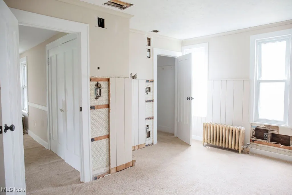 Unfurnished bedroom with baseboards, a closet, and light colored carpet