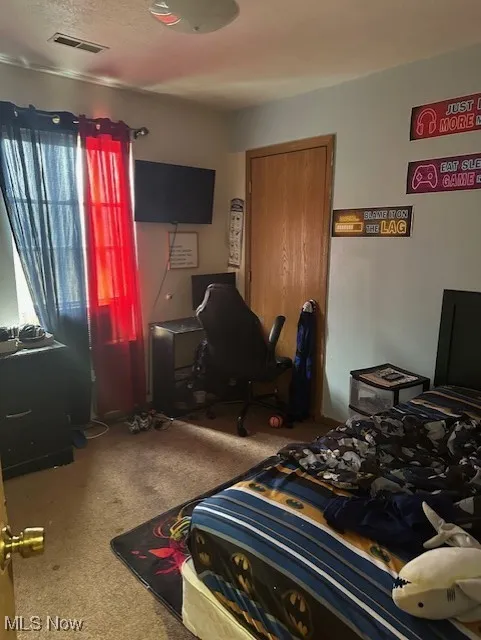 Bedroom featuring a closet, carpet floors, and visible vents