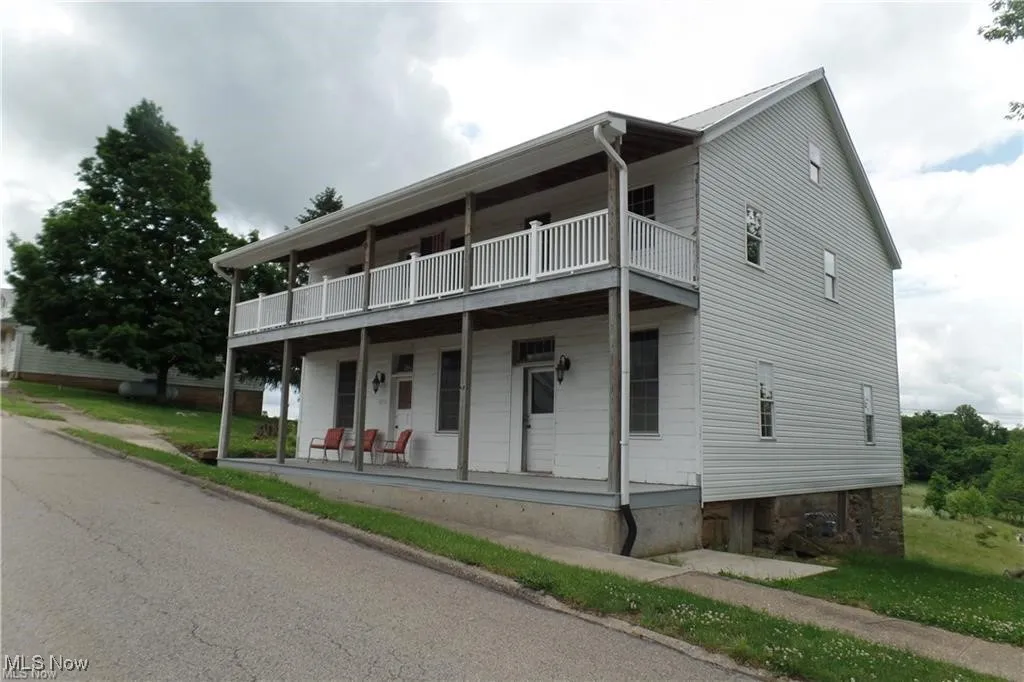 Multi unit property featuring covered porch and a balcony