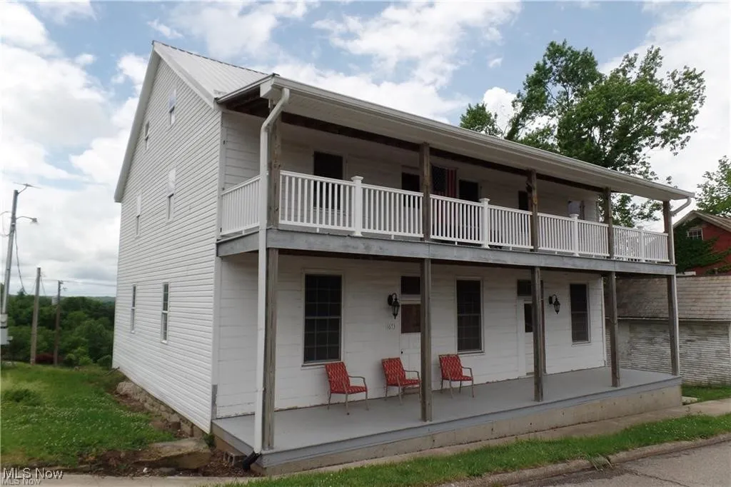 View of front of home with a porch and a balcony