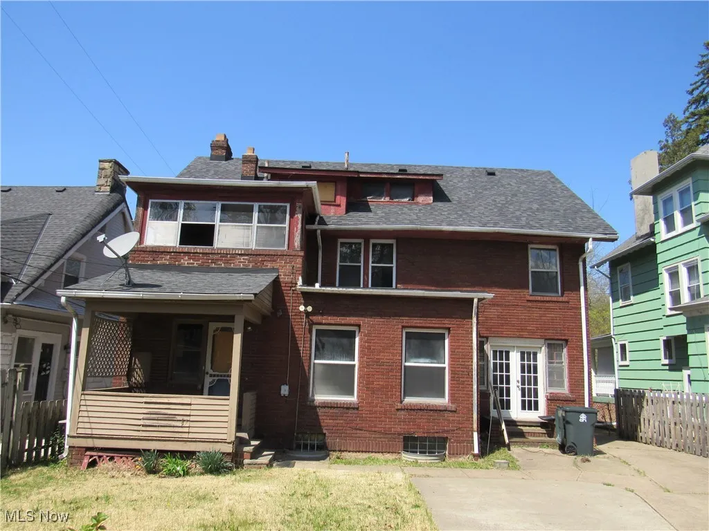 Back of property with a chimney, fence, brick siding, a shingled roof, and a patio